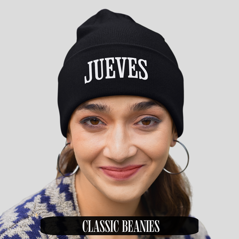 Frau trägt schwarzes Classic Beanie von Jueves Apparel mit weißem Jueves-Schriftzug – stylisches Streetwear-Accessoire für urbanen Look.
